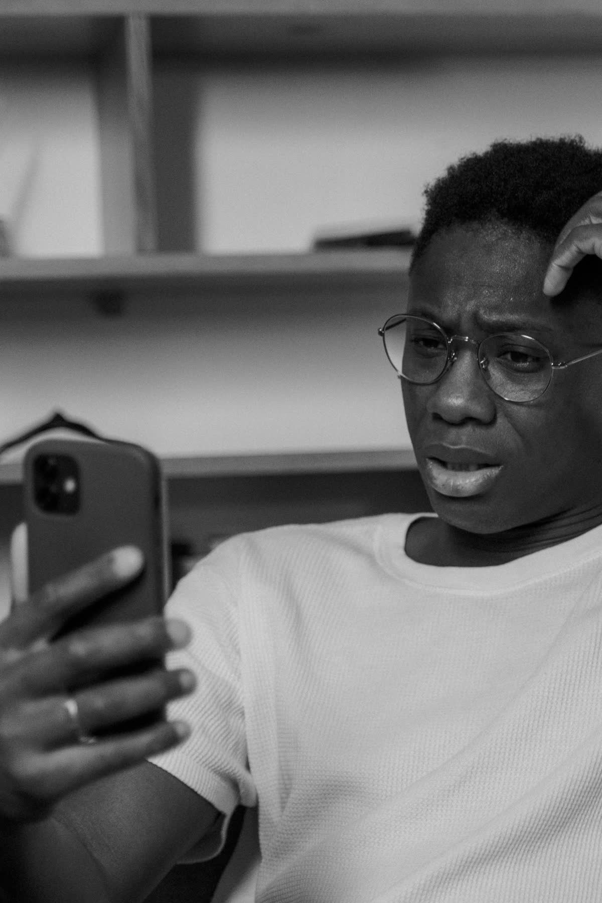 Pessoa segurando um celular, com expressão de angústia